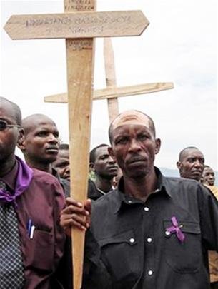 Disaster survivors hold crosses with the names of the 1994 genocide victims marching in the streets of Kigali 4-2006